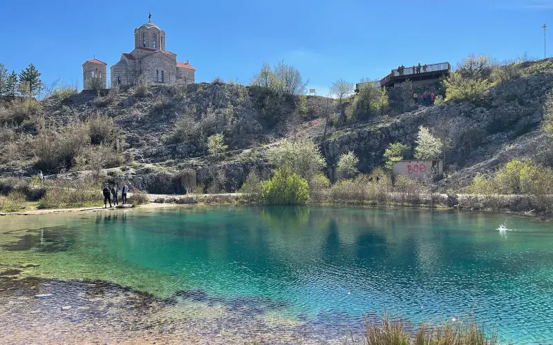 The emerald Cetina spring with the old church of the Holy Salvation on the hill above it