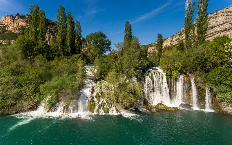 The cascades of Roški Slap spilling into the green water of the Krka river