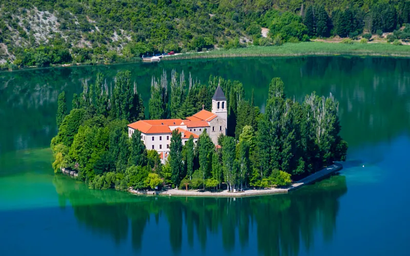 The wooded island of Visovac with its Franciscan monastery in the middle of the Krka river